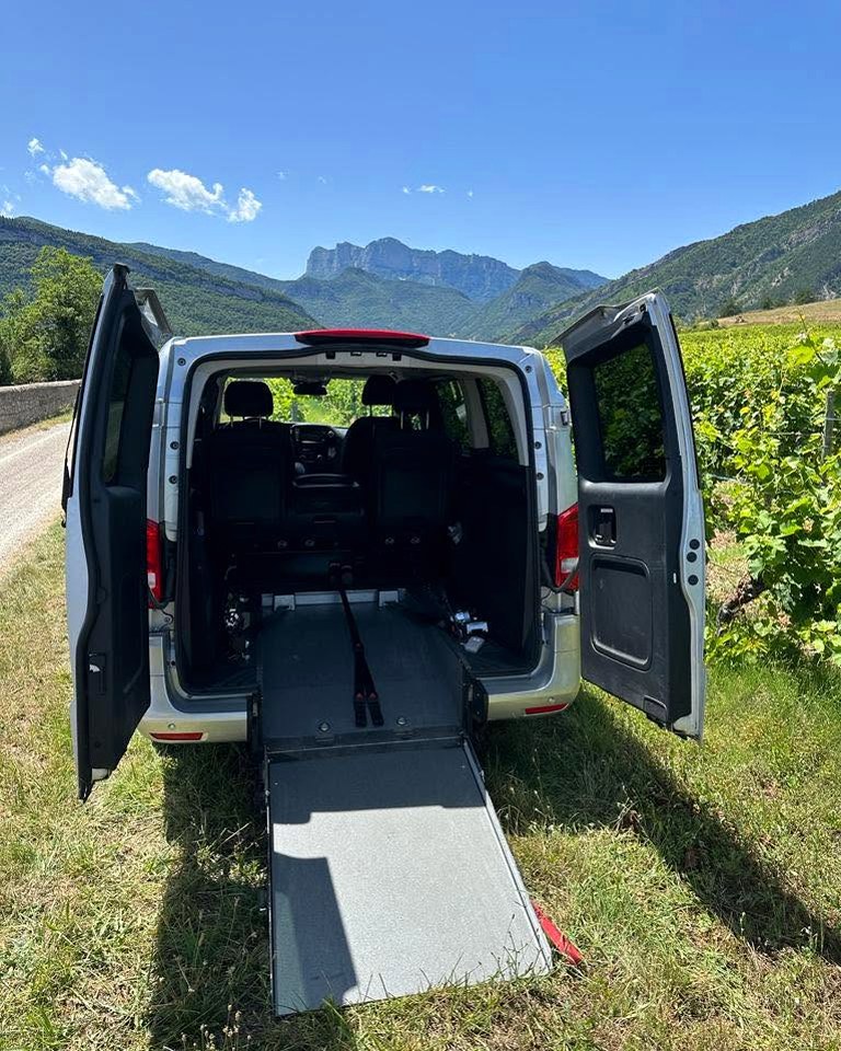 Minibus JO Taxis avec rampe d'accès fauteuil roulant dépliée, dans les vignes du Diois